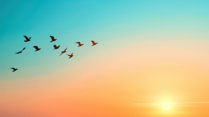 Fototapeta premium Silhouetted birds flying over a vibrant sunset sky