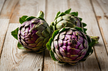Fototapeta premium Artichokes: Unveiling Their Beauty on Rustic Wood