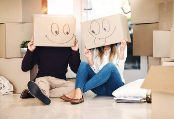 New home, box and couple with emoji on floor for property, moving day and mortgage. Homeowner, real estate and man and woman with funny face drawing for relocation, packing and rental apartment