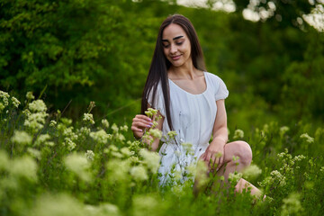 Beautiful latin woman on a meadow by the forest