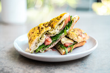 Grilled gourmet mozzarella veggie pesto sandwich on a white plate