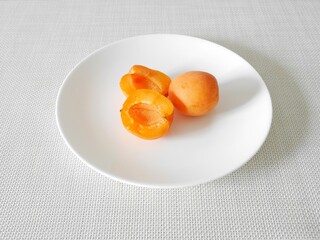 白い皿の上の生食用あんず「ハーコット」（断面）