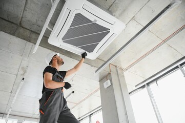 Happy Male Technician Repairing Air Conditioner