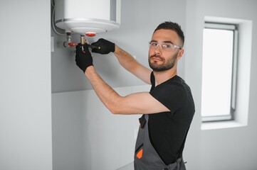 Professional plumber checking a boiler and pipes, boiler service concept