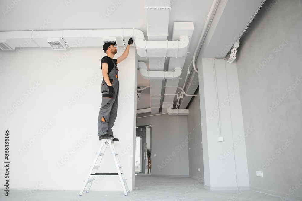 Wall mural hvac technician at work. ventilation, heating system maintenance and repair