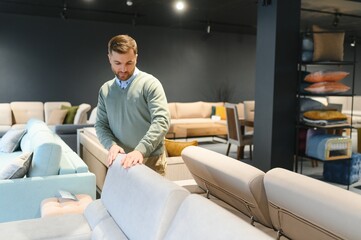 Man in furniture store choosing sofa