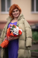 Portrait of a beautiful red-haired woman in a purple dress.