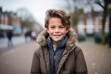 Fototapeta premium Portrait of a cute little boy in winter coat smiling at the camera
