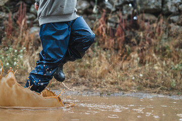 A person is running through a muddy puddle