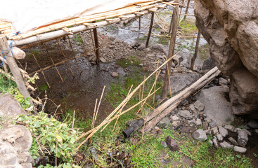 Bridge over mountain river on tourist route in Moroccan mountains, wooden planks, rocky terrain
