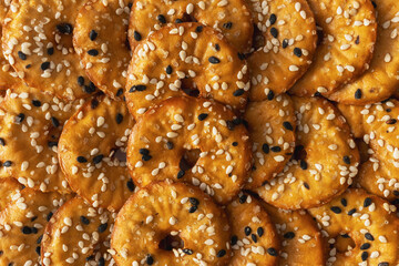 Salted round pretzels with black and white sesame, close up