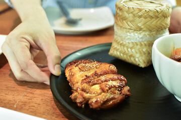 At Somtam restaurant, there is sticky rice and grilled pork on the plate.