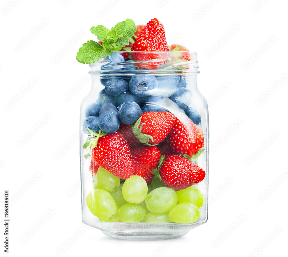 Wall mural glass jar with grapes, strawberries and blueberries on a white isolated background