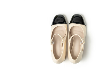 Studio photo of a Retro style pair of high heel women's shoes walk on a white background. Patent leather buckle female shoes. Beige high heel shoes with black tip. Clipping path included