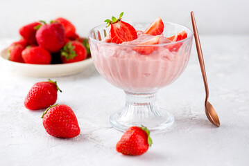 Vegan yogurt, whipped tofu and strawberry mousse dessert in a glass with spoon. Lactose and sugar free.