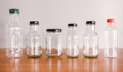 empty used glass bottle on wood desk with gray background. Recycle glass bottles. Safe the earth concept. 