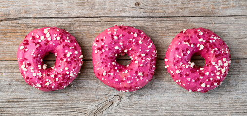 Set of colorful donuts on wooden background