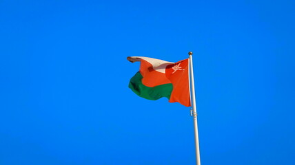 Tri-Colored National Oman Flag Waving Clear Blue Sky