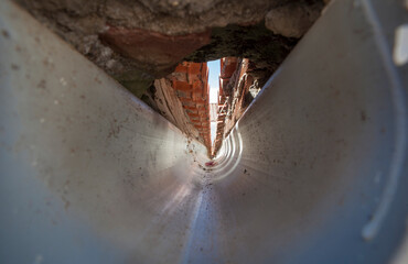 Interior of a PVC gutter at the confluence of a gable roof.