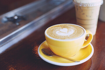 hot coffee cup latte art with spoon Serve ready to drink in cafe on wooden table coffee shop.  Leave copy space empty to write the side text. soft focus.