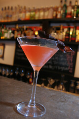 orange drink in martini glass on top of a bar