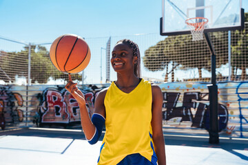 Black female basketball player training at city basketball court - Powered by Adobe