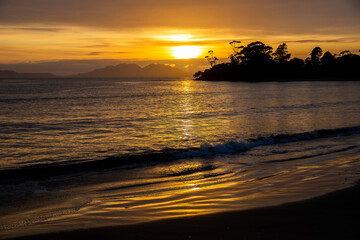 Golden sunrise with from Swansea, Tasmania, with Freycenit Peninsula silhouetted in the background.