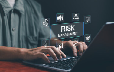 Concept of risk management and business assessment ,businessman using laptop to manage business risk,investment, analyze, evaluate, check for safety or risk reduction strategies on virtual screen