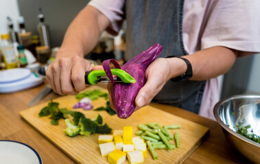 Chef at the kitchen preparing green curry with herbs and rice