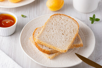 Slices of white bread and apricot jam for breakfas