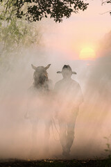 The silhouette of the cowboy and the setting sunset