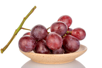 One bunch of sweet grapes in a  ceramic plate, macro, isolated on white background.