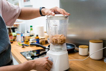 Chef at the kitchen preparing bean porridge with cauliflower and vegetables