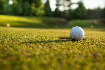 Golf ball and clubs in golf field