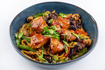 Udon stir-fry noodles with chicken meat and sesame in bowl on dark stone background copy space,