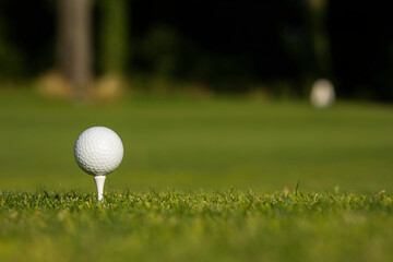 Golf ball and clubs in golf field