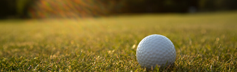 Golf ball and clubs in golf field