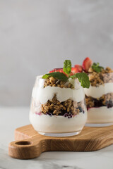Yogurt with crispy granola, berries and mint leaves for a delicious breakfast. Healthy eating.