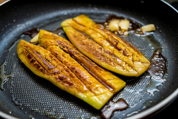 Delicious grilled eggplants with garlic on the fried pan