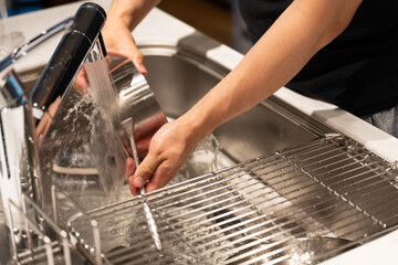 食器を洗う男性