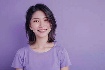 Fototapeta premium A woman with short hair and a purple shirt is smiling. She has a bright, happy expression on her face