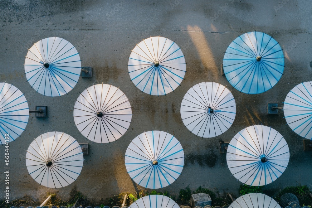 Aufkleber aerial symmetry of blue and white striped umbrellas geometric pattern and textured background in nat