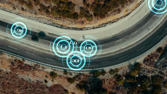 Aerial view of autonomous self-driving cars driving on a winding road. HUD signals around the vehicles, environment scanning, speed control, driverless transportation of the future. 4k footage