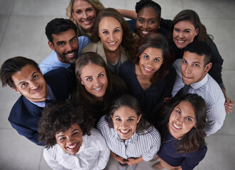 Collaboration, huddle and smile with portrait of business people in office together from above. Face, teamwork or unity with happy professional men and women in circle at workplace for solidarity