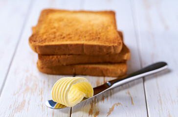 butter curl with toast bread on a wooden table, selective focus.