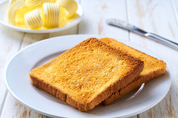 classic breakfast scene with toasted bread and butter, selective focus.