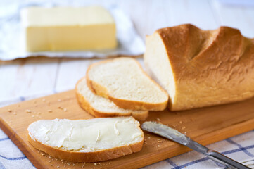Delicious white wheat bread and fresh butter on cutting board.