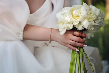 bride in white dress with bouquet of white flowers, closeup 