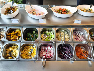 Buffet table stocked with an array of salads and veggies
