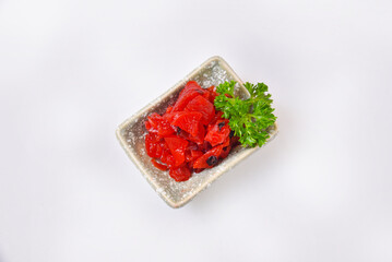 Red pickled lotus root in a ceramic cup Pickled lotus root is a popular accompaniment to Japanese and Korean food.